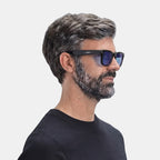 VAUCLIOR VC AXE GEN1 smart glasses with rectangular black frames and blue lenses, worn by a man.